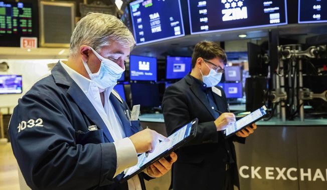 In this photo provided by the New York Stock Exchange, a pair of traders work on the floor, Tuesday Feb. 2, 2021. Stocks were broadly higher in afternoon trading Tuesday, but shares of closely watched companies like GameStop and AMC Entertainment were falling sharply. (Colin Ziemer/New York Stock Exchange via AP)