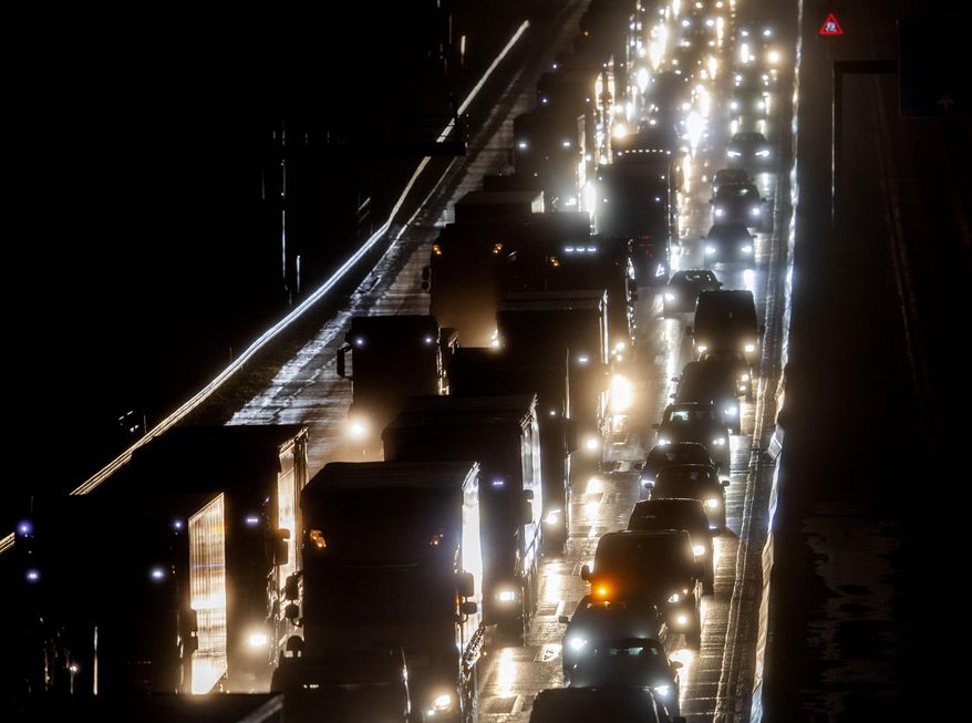 Cars and trucks drive on a highway in Frankfurt, Germany, on a rainy Friday, Jan. 29, 2021. (AP Photo/Michael Probst)