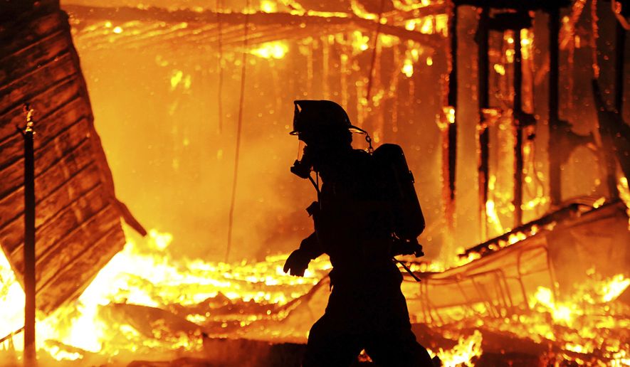 A firefighter works at the scene of a fire at the Town Hall building in Jefferson, N.H., Monday, Feb. 1, 2021, in Jefferson, N.H. No injuries were reported and no one was at the town hall at the time of the fire. (Paul Hayes/Caledonian-Record via AP)