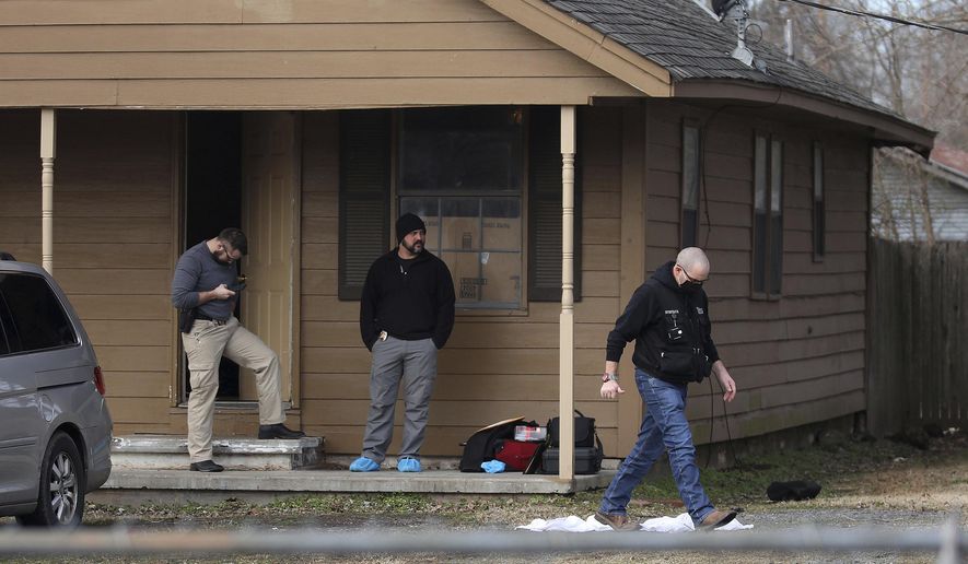 Investigators work at the scene of a shooting on Tuesday, Feb. 2, 2021 in Muskogee, Okla. Police say one person is in custody after six people, including five young children, were shot to death at a home about 45 miles southeast of Tulsa. (Mike Simons/Tulsa World via AP)