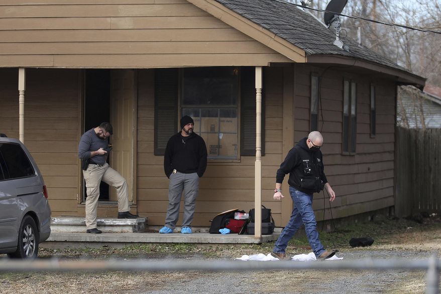 Investigators work at the scene of a shooting on Tuesday, Feb. 2, 2021 in Muskogee, Okla. Police say one person is in custody after six people, including five young children, were shot to death at a home about 45 miles southeast of Tulsa. (Mike Simons/Tulsa World via AP)