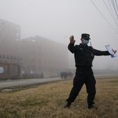 A security person moves journalists away from the Wuhan Institute of Virology after a World Health Organization team arrived for a field visit in Wuhan in China&#x27;s Hubei province on Wednesday, Feb. 3, 2021. The WHO team is investigating the origins of the coronavirus pandemic has visited two disease control centers in the province. (AP Photo/Ng Han Guan)
