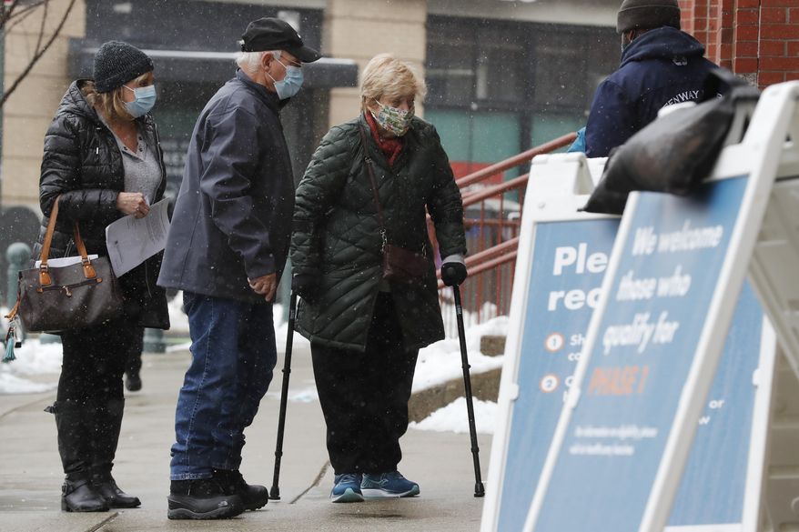People arrive at a COVID-19 vaccination site at Fenway Park, Tuesday, Feb. 2, 2021, in Boston. (AP Photo/Michael Dwyer)