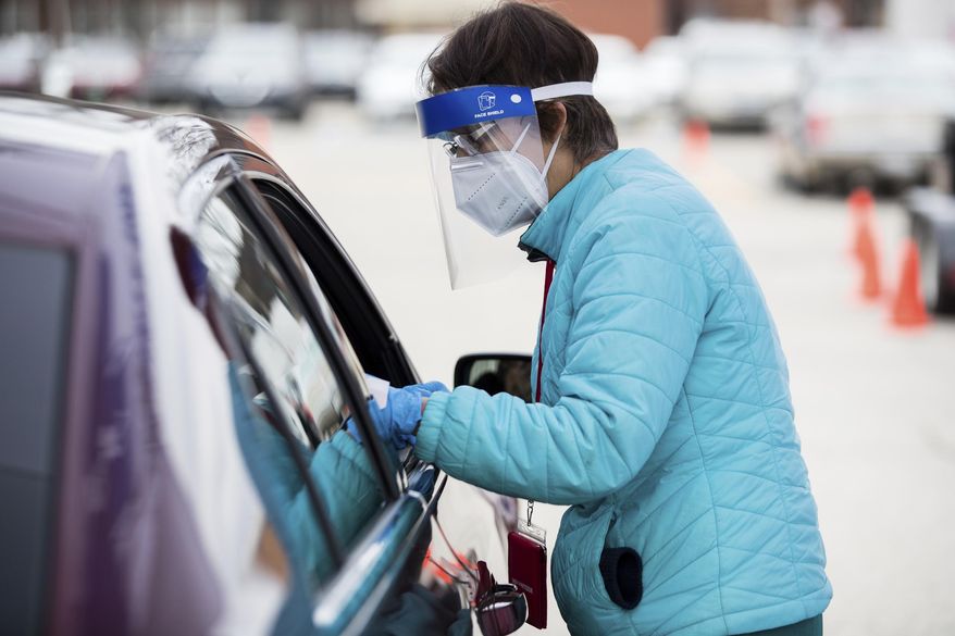 Registered Nurse Lynda Turner prepares to administer a COVID-19 vaccine as Cabell County EMS assists the Cabell-Huntington Health Department with the distribution of COVID-19 vaccines during a drive-thru clinic on Thursday, Jan. 21, 2021, outside of the St. Mary's School of Nursing in Huntington, W.Va. (Sholten Singer/The Herald-Dispatch via AP) ** FILE **