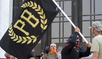 In this Sept. 7, 2020, file photo, a protester carries a Proud Boys banner, a right-wing group, while other members start to unfurl a large U.S. flag in front of the Oregon State Capitol in Salem, Ore. The Proud Boys are the target of a new lawsuit filed by the NAACP, which alleges the group to have violated the Ku Klux Klan Act in its actions in the Jan. 6 riot at the U.S. Capitol. (AP Photo/Andrew Selsky, File)  **FILE**