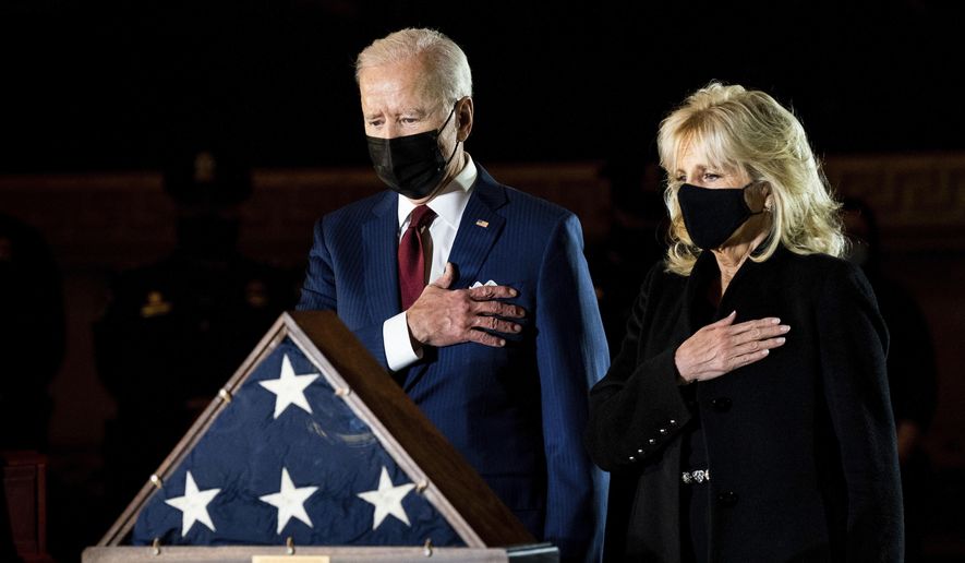 President Joe Biden and first lady Jill Biden pay their respects to the late U.S. Capitol Police officer Brian Sicknick as an urn with his cremated remains lies in honor on a black-draped table at the center of Capitol Rotunda, Tuesday, Feb. 2, 2021, in Washington. (Erin Schaff/The New York Times via AP, Pool)