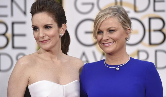 FILE - In this Jan. 11, 2015, file photo, Tina Fey, left, and Amy Poehler arrive at the 72nd annual Golden Globe Awards in Beverly Hills, Calif. The 78th Golden Globes will for the first time be held on two coasts, with Tina Fey live in New York and Amy Poehler in Beverly Hills, Calif., a person close to the show said Tuesday, Feb. 2, 2021, as the annual Hollywood ceremony adapts to the pandemic. (Photo by John Shearer/Invision/AP, File)