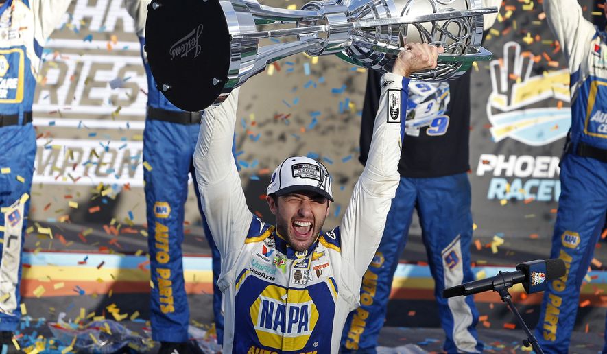 Chase Elliott holds up the season championship trophy as he celebrates with his race crew in Victory Lane after winning the NASCAR Cup Series auto race at Phoenix Raceway in Avondale, Ariz., in this Sunday, Nov. 8, 2020, file photo. NASCAR is being heavily promoted by a broadcast partner as about to embark on “The Best Season Ever” and on paper that could be true. NASCAR this year will race on dirt for the first time since 1970, the schedule includes a whopping seven road courses and five venues new to the Cup Series. Michael Jordan and Pitbull are among new team owners entering the sport in 2021 and Chase Elliott, NASCAR’s most popular driver, is the reigning champion. (AP Photo/Ralph Freso, File) **FILE**