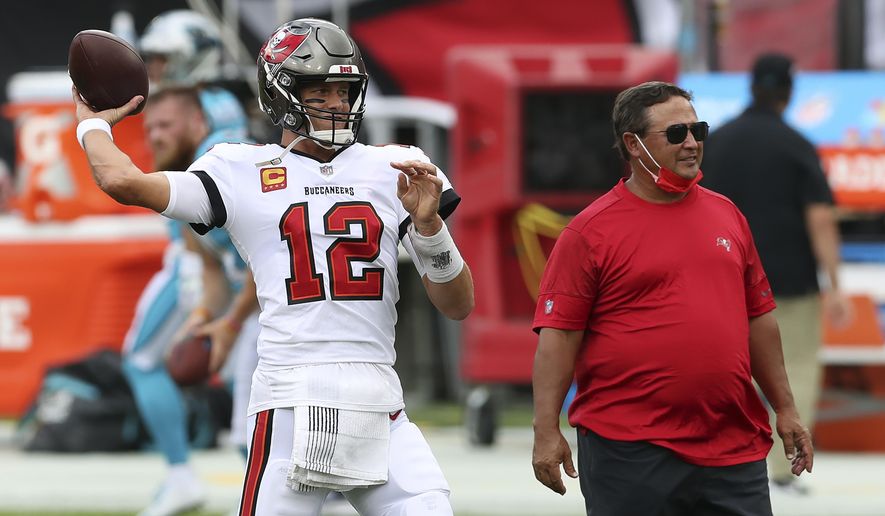 Tampa Bay Buccaneers quarterback Tom Brady (12) throws a pass as quarterback&#39;s coach Clyde Christensen looks on before an NFL football game against the Carolina Panthers Sunday, Sept. 20, 2020, in Tampa, Fla. (AP Photo/Mark LoMoglio)