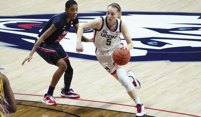 Connecticut guard Paige Bueckers (5) drives the ball against St. John&#x27;s guard Kadaja Bailey (30) during the first half of an NCAA college basketball game Wednesday, Feb. 3, 2021, in Storrs, Conn. (David Butler II/Pool Photo via AP)