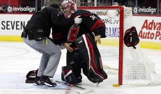 Carolina Hurricanes goaltender Petr Mrazek (34) is helped up by a team trainer after an injury during the first period of the team&#x27;s NHL hockey game against the Dallas Stars in Raleigh, N.C., Saturday, Jan. 30, 2021. (AP Photo/Karl B DeBlaker)