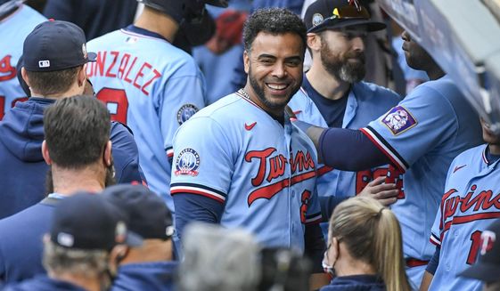 FILE - In this Sept. 27, 2020, file photo, Minnesota Twins&#39; Nelson Cruz, center, smiles in the dugout after the Twins clinched the AL Central championship with the Chicago White Sox&#39;s loss during the tenth inning of a baseball game in Minneapolis. The Minnesota Twins are bringing back designated hitter Nelson Cruz on a one-year, $13 million contract, according to a person with knowledge of the negotiations. The agreement was reached late Tuesday and confirmed Wednesday, Feb. 3, 2021, to The Associated Press on condition of anonymity because the deal was pending completion of a physical exam.(AP Photo/Craig Lassig, File)