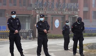 Security personnel gather near the entrance of the Wuhan Institute of Virology during a visit by the World Health Organization team in Wuhan in China&#39;s Hubei province on Wednesday, Feb. 3, 2021. (AP Photo/Ng Han Guan)