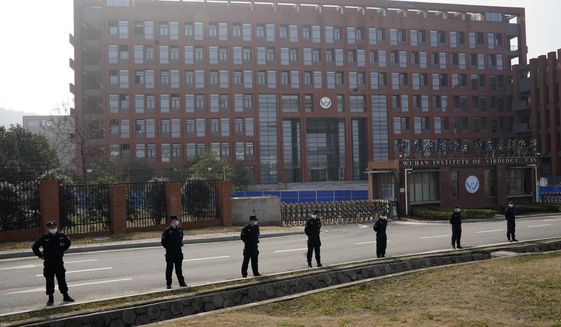Security personnel gather near the entrance to the Wuhan Institute of Virology during a visit by the World Health Organization team in Wuhan in China&#39;s Hubei province on Wednesday, Feb. 3, 2021. The WHO team is investigating the origins of the coronavirus pandemic has visited two disease control centers in the province. (AP Photo/Ng Han Guan)