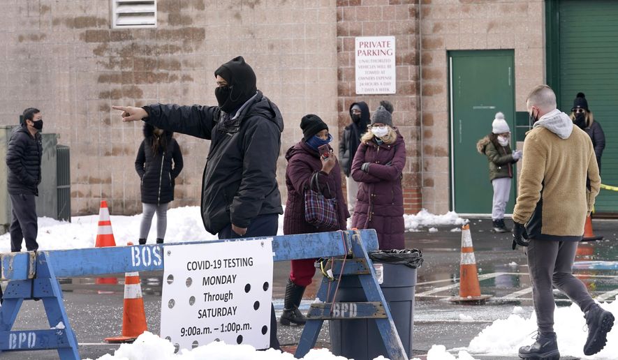 People on line are directed at a COVID-19 testing site, Wednesday, Feb. 3, 2021, in Boston's Roxbury section. (AP Photo/Elise Amendola)