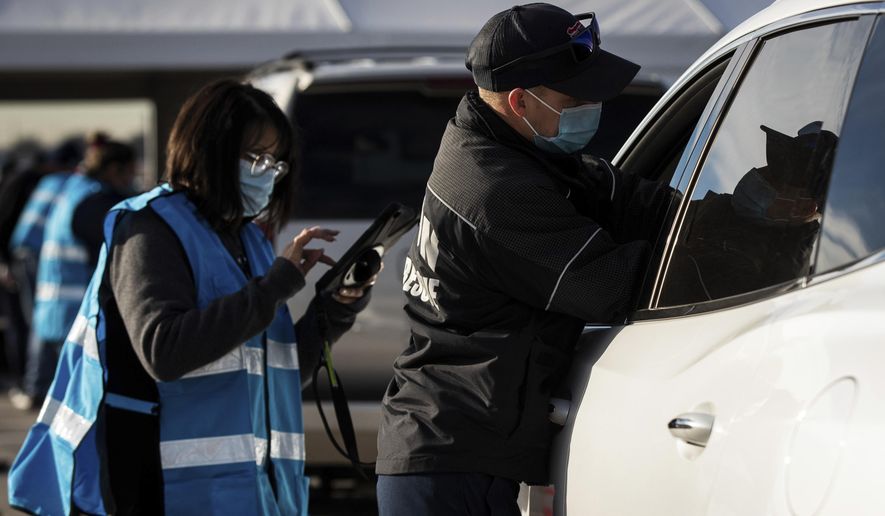 Matt Dieter, with Denton Fire Department administers a COVID-19 vaccine, Tuesday, Feb. 2, 2021, at the Texas Motor Speedway in Fort Worth, Texas. (Yffy Yossifor/Star-Telegram via AP)