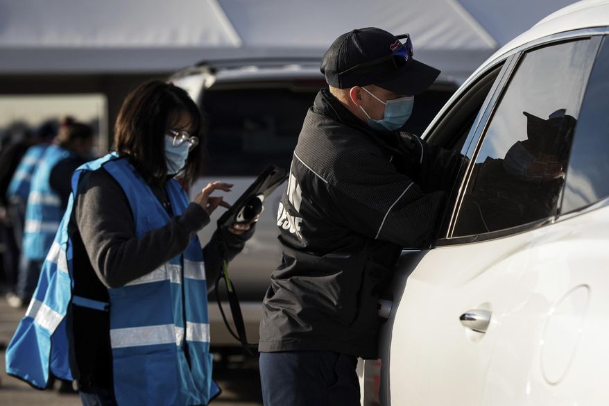 Matt Dieter, with Denton Fire Department administers a COVID-19 vaccine, Tuesday, Feb. 2, 2021, at the Texas Motor Speedway in Fort Worth, Texas. (Yffy Yossifor/Star-Telegram via AP)
