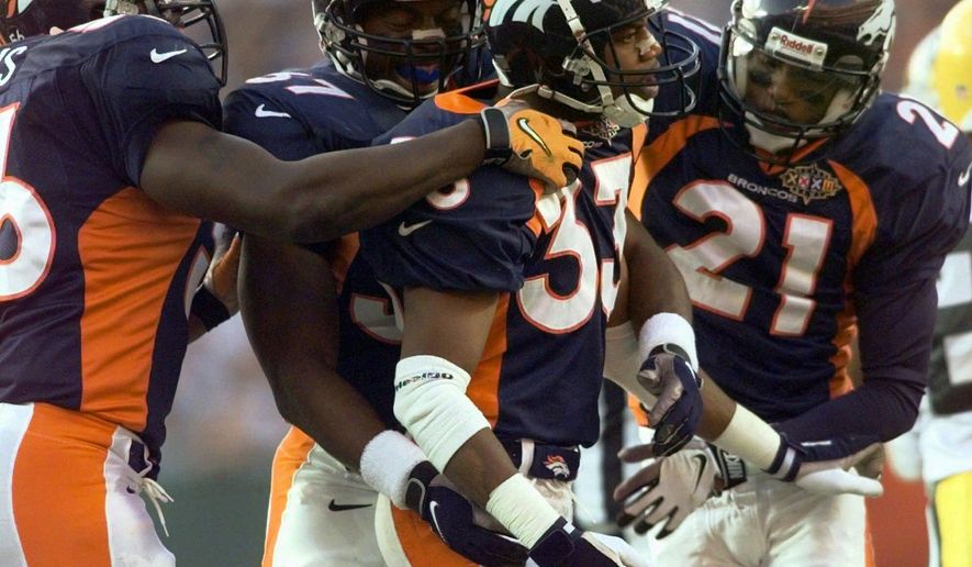 FILE - In this file photo dated Sunday, Jan. 25, 1998, Denver Broncos Dedrick Dodge (33) celebrates with teammates Randy Hilliard (21) and Anthony Lynn (37) after he stopped Green Bay Packers&#39; Antonio Freeman on a kickoff return in the second quarter of Super Bowl XXXII, at San Diego&#39;s Qualcomm Stadium.  The year 2021 marks the 30th anniversary of the World League of American Football, and Dedrick Dodge joined the London Monarchs and helped them win the first World Bowl in 1991. (AP Photo/Susan Ragan, FILE)