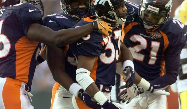 FILE - In this file photo dated Sunday, Jan. 25, 1998, Denver Broncos Dedrick Dodge (33) celebrates with teammates Randy Hilliard (21) and Anthony Lynn (37) after he stopped Green Bay Packers&#x27; Antonio Freeman on a kickoff return in the second quarter of Super Bowl XXXII, at San Diego&#x27;s Qualcomm Stadium.  The year 2021 marks the 30th anniversary of the World League of American Football, and Dedrick Dodge joined the London Monarchs and helped them win the first World Bowl in 1991. (AP Photo/Susan Ragan, FILE)