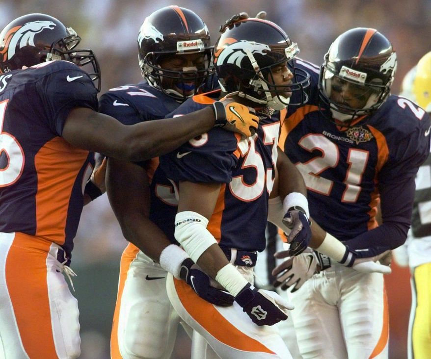 FILE - In this file photo dated Sunday, Jan. 25, 1998, Denver Broncos Dedrick Dodge (33) celebrates with teammates Randy Hilliard (21) and Anthony Lynn (37) after he stopped Green Bay Packers&#x27; Antonio Freeman on a kickoff return in the second quarter of Super Bowl XXXII, at San Diego&#x27;s Qualcomm Stadium.  The year 2021 marks the 30th anniversary of the World League of American Football, and Dedrick Dodge joined the London Monarchs and helped them win the first World Bowl in 1991. (AP Photo/Susan Ragan, FILE)