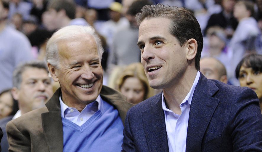 Then Vice President Joe Biden, left, and his son Hunter Biden appear at the Duke Georgetown NCAA college basketball game in Washington on Jan. 30, 2010. (AP Photo/Nick Wass, File)  **FILE**