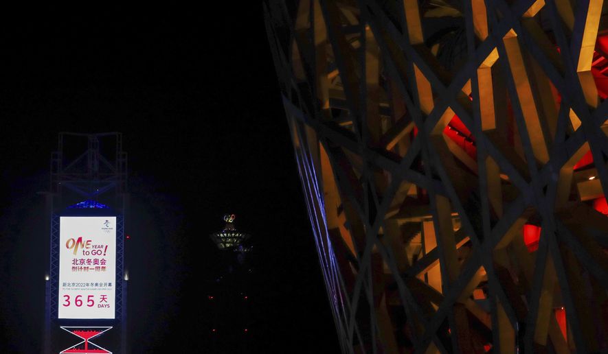 A countdown clock showing one year to go for the 2022 Beijing Olympics stands near the Olympics Tower, far center, and National Stadium, also known as the Bird&#39;s Nest, which will again be a venue for the Olympics, in Beijing on Wednesday, Feb. 3, 2021. The 2022 Beijing Winter Olympics will open a year from now. Most of the venues have been completed as the Chinese capital becomes the first city to hold both the Winter and Summer Olympics. Beijing held the 2008 Summer Olympics. But these Olympics are presenting some major problems. They are already scarred by accusations of rights abuses including &amp;quot;genocide&amp;quot;against more than 1 million Uighurs and other Muslim ethnic groups in western China. (AP Photo/Andy Wong)
