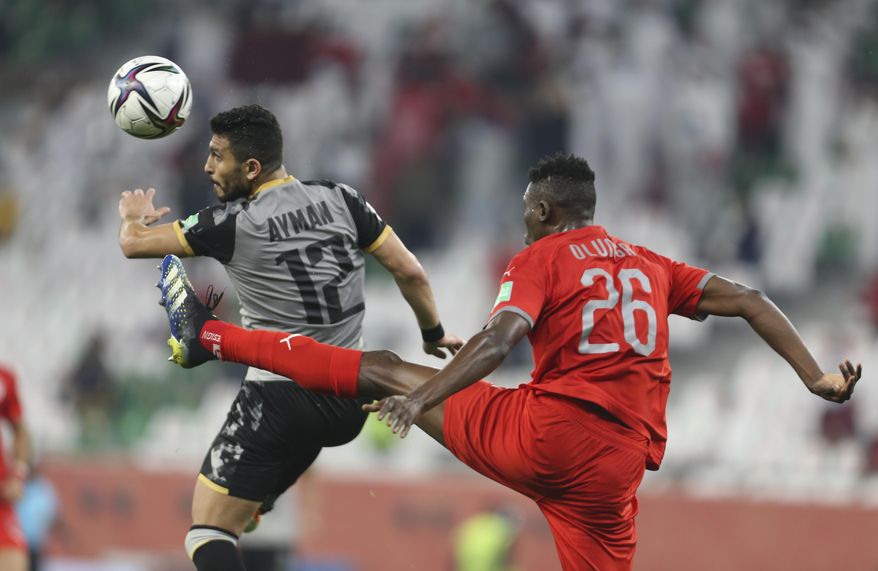 Al Duhail's Michael Olunga, rightt, and Al Ahly's Ashraf Ayman fight for the ball during FIFA Club World Cup in Al Rayyan, Qatar, Thursday, Feb. 4, 2021. (AP Photo/Hussein Sayed)