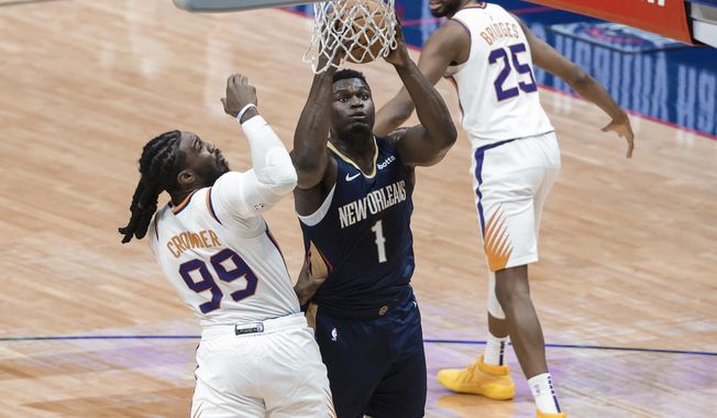 New Orleans Pelicans forward Zion Williamson (1) shoots past Phoenix Suns forward Jae Crowder (99) during the first half of an NBA basketball game in New Orleans, Wednesday, Feb. 3, 2021. (AP Photo/Derick Hingle)