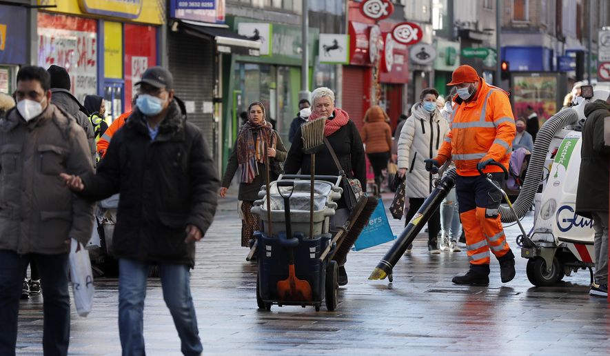 Road cleaners work in the town centre of Ilford in London, Friday, Jan. 29, 2021. In parts of east London, the pandemic is hitting much harder than most places in the U.K. The borough of Redbridge had the nation's second worst infection rate in January, with an estimated 1 in 15 residents thought to be infected. (AP Photo/Frank Augstein)