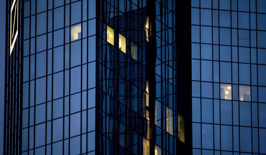 A few lights are on in the offices of the Deutsche Bank headquarters in Frankfurt, Germany, Wednesday, Jan. 27, 2021 as the partial lockdown in Germany goes on. (AP Photo/Michael Probst)