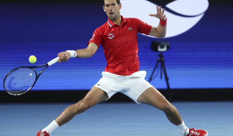 Serbia's Novak Djokovic makes a forehand return to Germany's Alexander Zverev during their ATP Cup match in Melbourne, Australia, Friday, Feb. 5, 2021.(AP Photo/Hamish Blair)