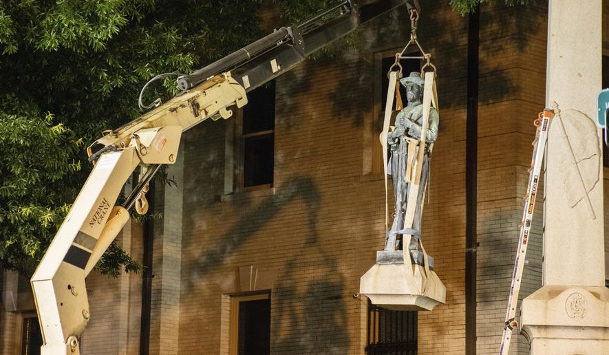This photo shows the removal of a Confederate statue in Greenville, North Carolina, on Monday, June 22, 2020. Crews on Monday removed the bronze statue that tops the monument outside the Pitt County Courthouse in Greenville. (Pitt County Public Information Office via AP)