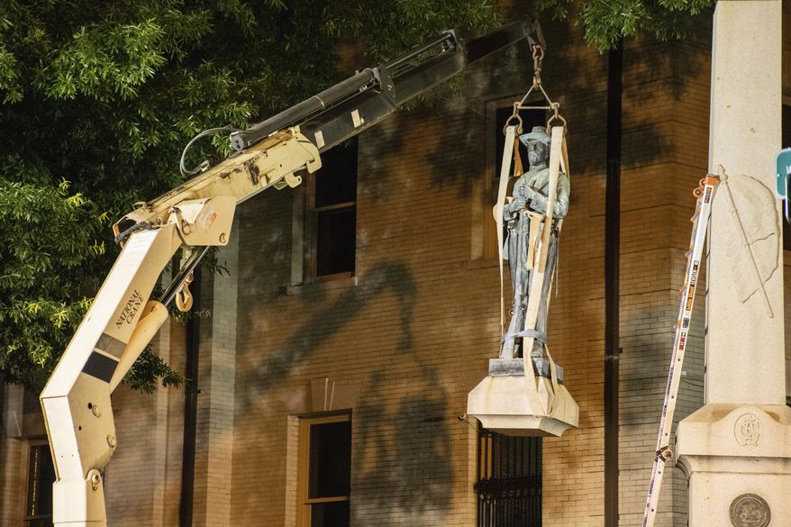 This photo shows the removal of a Confederate statue in Greenville, North Carolina, on Monday, June 22, 2020. Crews on Monday removed the bronze statue that tops the monument outside the Pitt County Courthouse in Greenville. (Pitt County Public Information Office via AP)