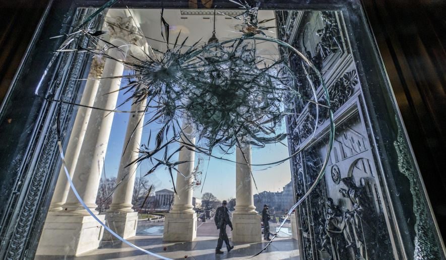 FILE - In this Jan. 12, 2021, file photo, shattered glass from the attack on Congress by a pro-Trump mob is seen in the doors leading to the Capitol Rotunda, in Washington. (AP Photo/J. Scott Applewhite, File)