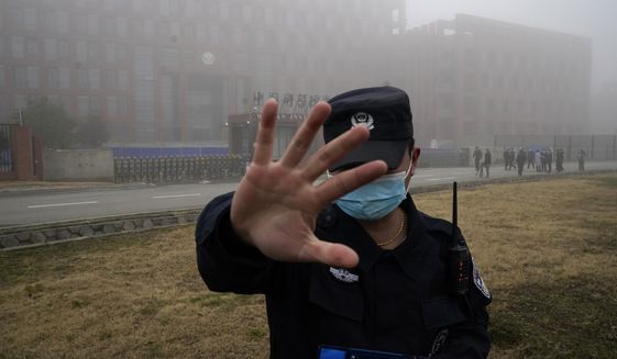 In this Feb. 3, 2021, file photo, a security person moves journalists away from the Wuhan Institute of Virology after a World Health Organization team arrived for a field visit in Wuhan in China&#39;s Hubei province. A member of the expert team investigating the origins of the coronavirus in Wuhan says the Chinese side granted full access to all sites and personnel they requested to visit and meet with. (AP Photo/Ng Han Guan, File)  **FILE**
