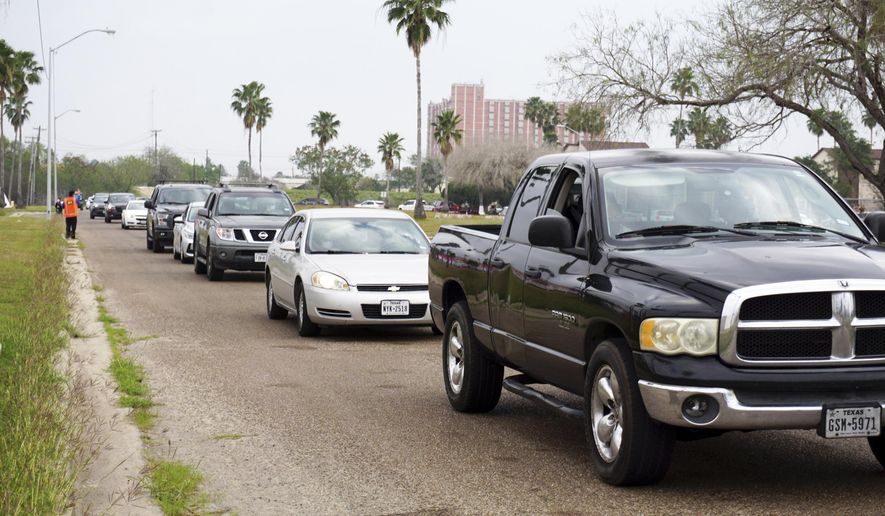 Motorist form a line while waiting for COVID-19 vaccines, Friday, Feb. 5, 2021, in Brownsville, Texas, during a vaccination clinic at Texas Southmost College (TSC) ITEC Center. (Miguel Roberts/The Brownsville Herald via AP)