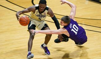 Northwestern forward Miller Kopp (10) dives for the ball with Purdue guard Brandon Newman (5) during the first half of an NCAA college basketball game in West Lafayette, Ind., Saturday, Feb. 6, 2021. (AP Photo/Michael Conroy)