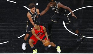 Toronto Raptors guard Kyle Lowry (7) is defended by Atlanta Hawks&#x27; Trae Young (11) and and Clint Capela (15) during the first half of an NBA basketball game Saturday, Feb. 6, 2021, in Atlanta. (AP Photo/Todd Kirkland)