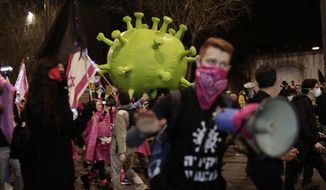 Israeli protesters march with a large inflatable model of the coronavirus on their way to Israeli Prime Minister Benjamin Netanyahu&#39;s official residence in Jerusalem, Saturday, Feb. 6, 2021. (AP Photo/Maya Alleruzzo)