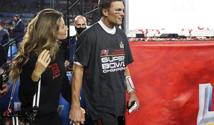 Tampa Bay Buccaneers quarterback Tom Brady (12) walks with his wife, Gisele Bündchen, following the NFL Super Bowl 55 football game against the Kansas City Chiefs, Sunday, Feb. 7, 2021, in Tampa, Fla. Tampa Bay won 31-9 to win Super Bowl LV. (Ben Liebenberg via AP)