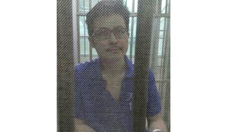 FILE - In this December 2014, file photo, Yang Maodong, better known by his penname Guo Feixiong, sits in a detention center in Guangzhou in southern China&#39;s Guangdong province. Guo&#39;s sister Yang Maoping said Tuesday, Feb. 2, 20201 that they had no word from Guo or information from police since he was reportedly detained at Shanghai&#39;s Pudong airport while attempting to board a flight to the U.S. (Photo via AP, File)