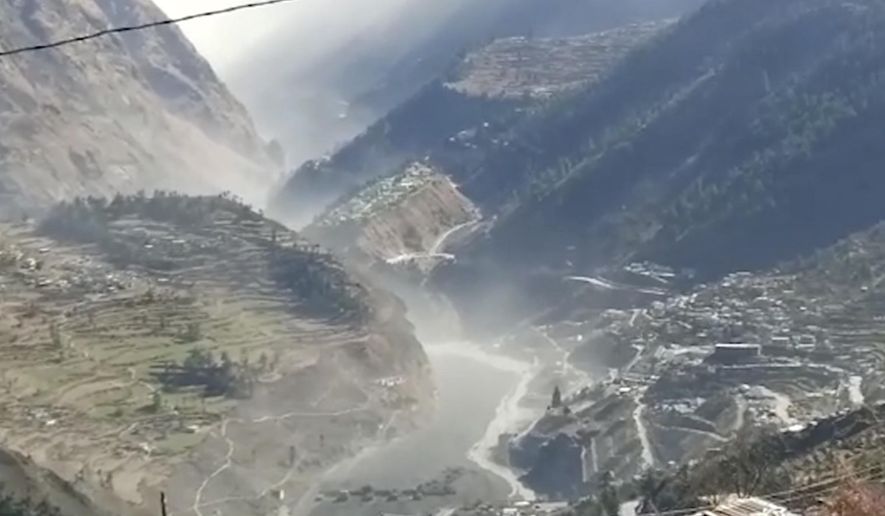 This frame grab from video provided by KK Productions shows a massive flood of water, mud and debris flowing at Chamoli District after a portion of Nanda Devi glacier broke off in Tapovan area of the northern state of Uttarakhand, India, Sunday, Feb.7, 2021. (KK Productions via AP)