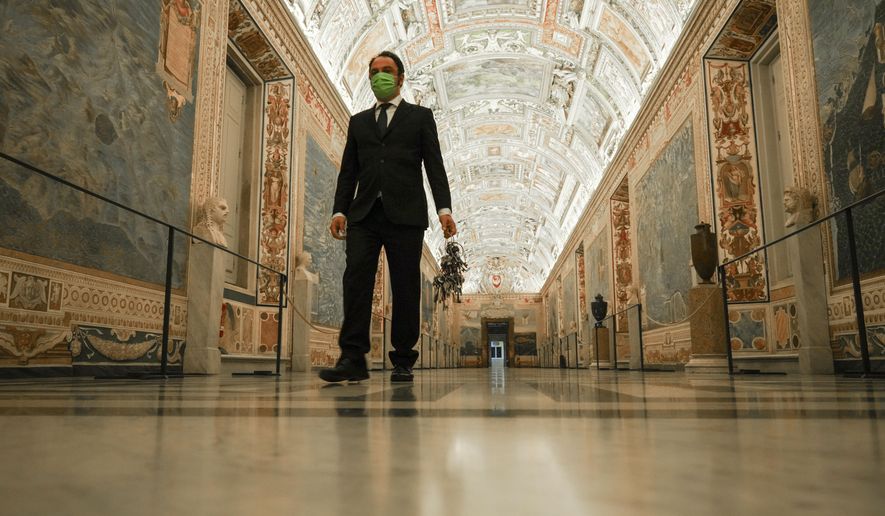 Gianni Crea, the Vatican Museums chief "Clavigero" key-keeper, holds a bunch of keys as he walks down the "Maps Aisle" to open the museum's rooms and sections, at the Vatican, Monday, Feb. 1, 2021. Crea is the “clavigero” of the Vatican Museums, the chief key-keeper whose job begins each morning at 5 a.m., opening the doors and turning on the lights through 7 kilometers of one of the world's greatest collections of art and antiquities. The Associated Press followed Crea on his rounds the first day the museum reopened to the public, joining him in the underground “bunker” where the 2,797 keys to the Vatican treasures are kept in wall safes overnight. (AP Photo/Andrew Medichini)