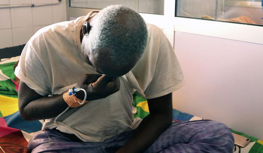 Ousseni Yanogo, 63, sits on his bed at Ouagadougou&#39;s Bogodogo Medical Teaching Hospital Thursday Feb. 4, 2021. Yanogo contracted COVID-19 at his 6-year-old grand-daughter&#39;s birthday. Since November, the conflict-riddled West African nation of Burkina Faso faces a much deadlier second coronavirus wave than the first and health officials worry a lack of knowledge and adherence to coronavirus measures is making it hard to rein in. (AP Photo/Sam Mednick)