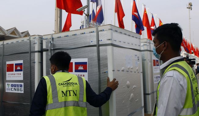 Workers pull boxes loaded with COVID-19 vaccines before a handing over ceremony at Phnom Penh International Airport, in Phnom Penh, Cambodia, Sunday, Feb. 7, 2021. Cambodia on Sunday received its first shipment of COVID-19 vaccine, a donation of 600,000 doses from China, the country&#x27;s biggest ally. Beijing has been making such donations to several Southeast Asian and African nations in what has been dubbed &amp;quot;vaccine diplomacy,&amp;quot; aimed especially at poorer countries like Cambodia. (AP Photo/Heng Sinith)