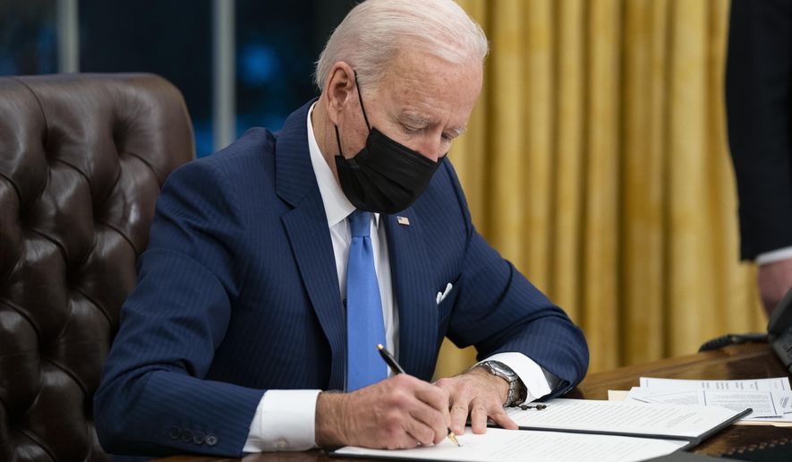 FILE - In this Feb. 2, 2021, file photo President Joe Biden signs an executive order on immigration, in the Oval Office of the White House in Washington. Biden rushed to send the most ambitious overhaul of the nation’s immigration system in a generation to Congress. And he signed nine executive actions to wipe out some of his predecessor’s toughest measures to fortify the U.S.-Mexico border. (AP Photo/Evan Vucci, File)