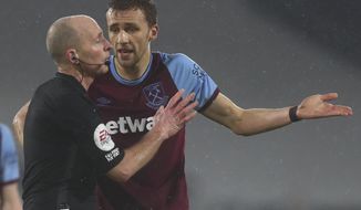 West Ham&#x27;s Tomas Soucek, center, talks to the referee after he was shown a red card during the English Premier League match between Fulham and West Ham at the Craven Cottage stadium in London, Saturday, Feb. 6, 2021. (Clive Rose/Pool via AP)