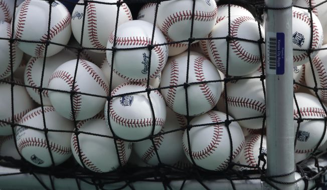 In this July 3, 2020, file photo, balls marked with Cactus League spring training logos are in a basket during Kansas City Royals baseball practice at Kauffman Stadium in Kansas City, Mo. Major League Baseball has slightly deadened its baseballs amid a years-long surge in home runs.MLB anticipates the changes will be subtle, and a memo to teams last week cites an independent lab that found the new balls will fly 1 to 2 feet shorter on balls hit over 375 feet. (AP Photo/Charlie Riedel, File)