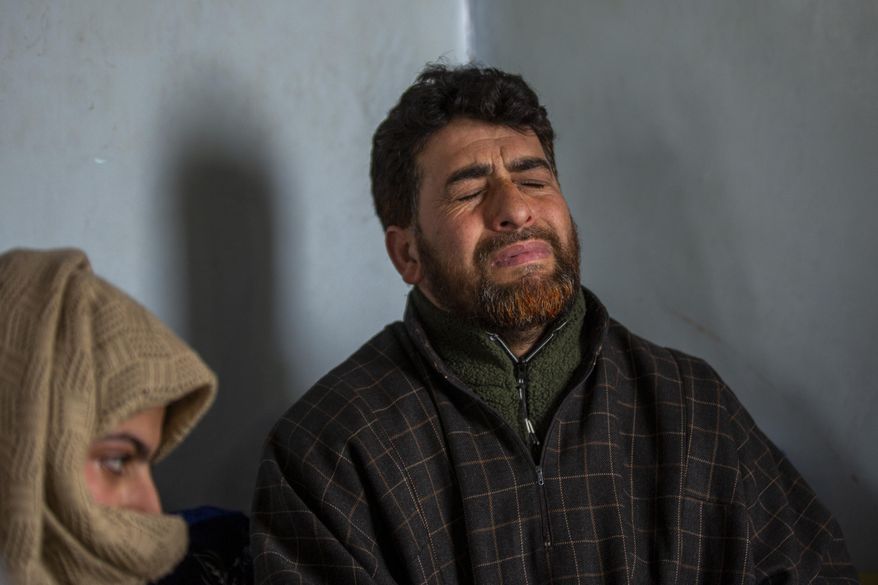 FILE-In this Jan. 5, 2021 file photo, Mushtaq Ahmad Wani, father of 16-year-old Athar Mushtaq, who was fatally shot by Government forces grieves while talking to Associated Press in Bellow, south of Srinagar, Indian controlled Kashmir. Police have booked the Kashmiri man seeking the body of his slain teenage son under India’s harsh anti-terror law, accusing him of organizing illegal processions under criminal conspiracy. (AP Photo/ Dar Yasin, File)