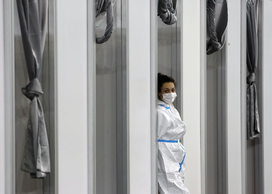 A medical worker wearing protective gear waits for people to receive the COVID-19 vaccine, at Belgrade Fair makeshift vaccination center in Belgrade, Serbia, Tuesday, Feb. 9, 2021. China is ready to consider &amp;quot;vaccine cooperation&amp;quot; with Central and Eastern European countries, President Xi Jinping said Tuesday in a meeting held by video link with European leaders. Serbia has received 1 million doses of a Chinese-developed coronavirus vaccine and Hungarian and Chinese vaccine developers are cooperating. (AP Photo/Darko Vojinovic)